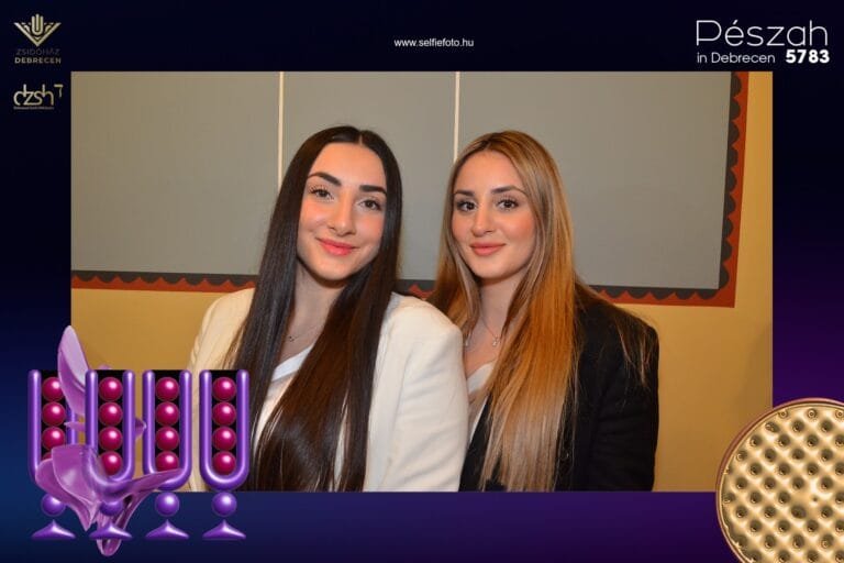 Selfiebox bérlés Debrecenben baráti társaságoknak.Két mosolygós fiatal hölgy a debreceni selfiebox-ban, elegáns fehér és fekete öltözékben, hosszú hajjal. A fotóautomata tökéletes szórakozás céges partikra, születésnapi összejövetelekre, lánybúcsúkra vagy baráti találkozókra. Modern party fotózás és instant emlékek készítése rendezvényeken.
